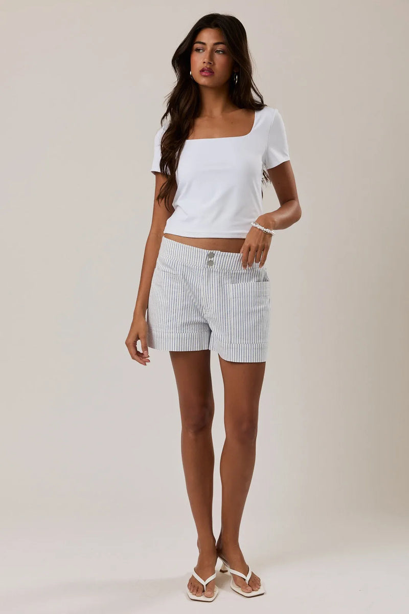 Mid rise stripe short featuring white and navy blue vertically striped denim shorts with button closure