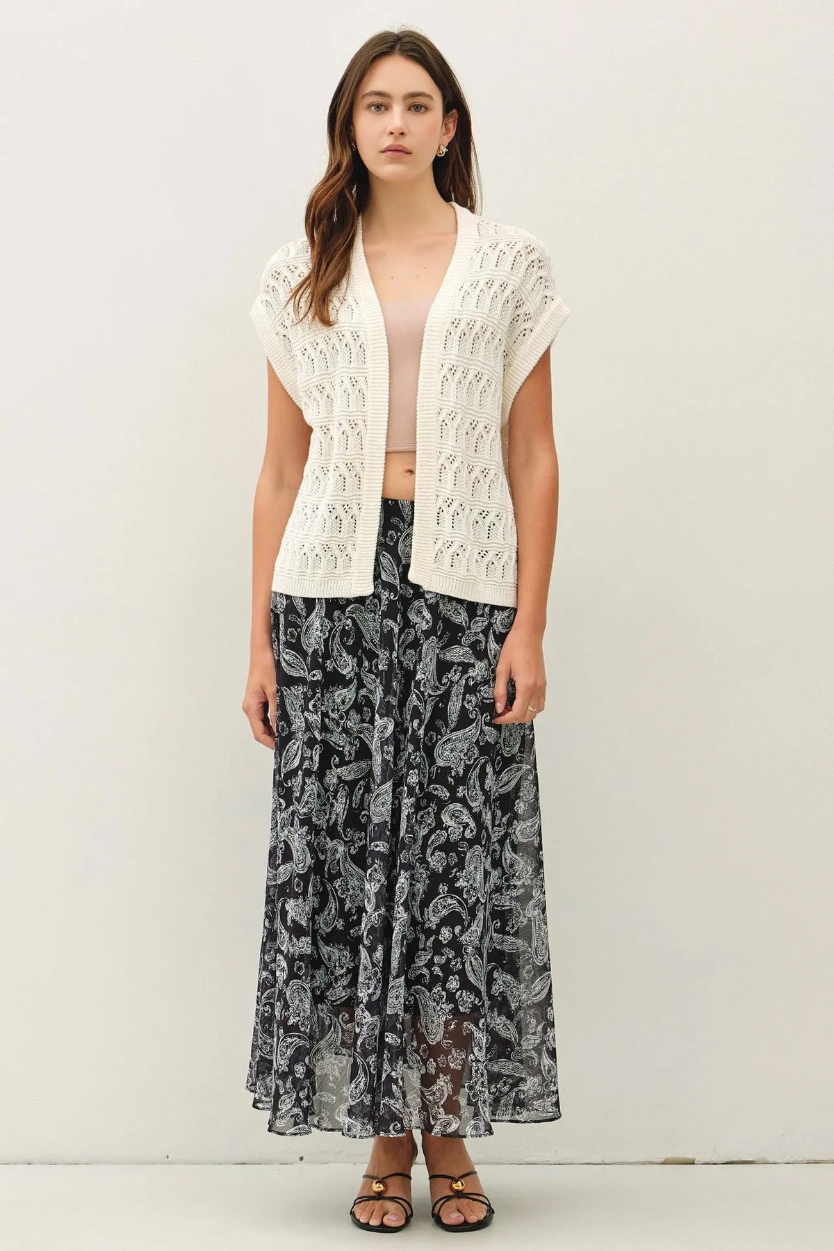 A white crochet knit boxy open cardigan featuring an open-front design with a detailed lace-like pattern