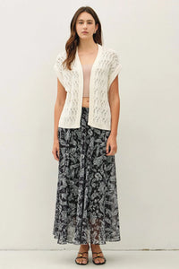 A white crochet knit boxy open cardigan featuring an open-front design with a detailed lace-like pattern