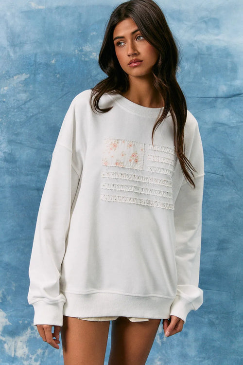 White oversized long sleeve crew neck sweatshirt with floral lace appliqué and usa flag design on front