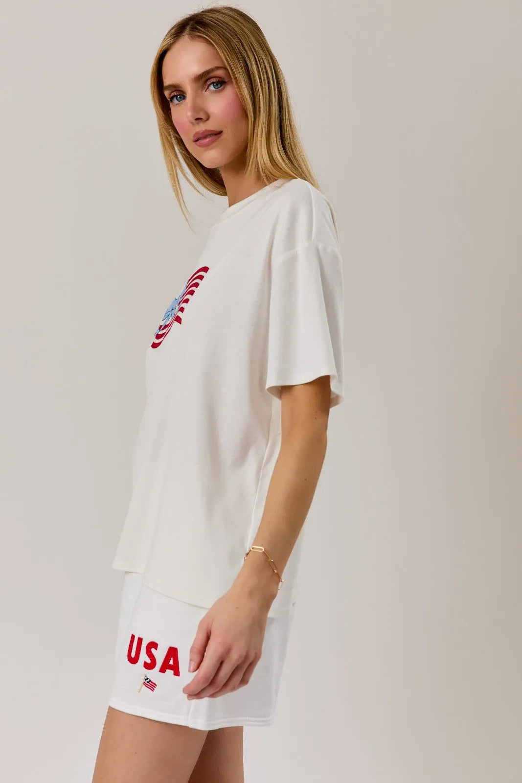 White oversized round neck t shirt with usa flag graphic embroidered in red and blue on the chest