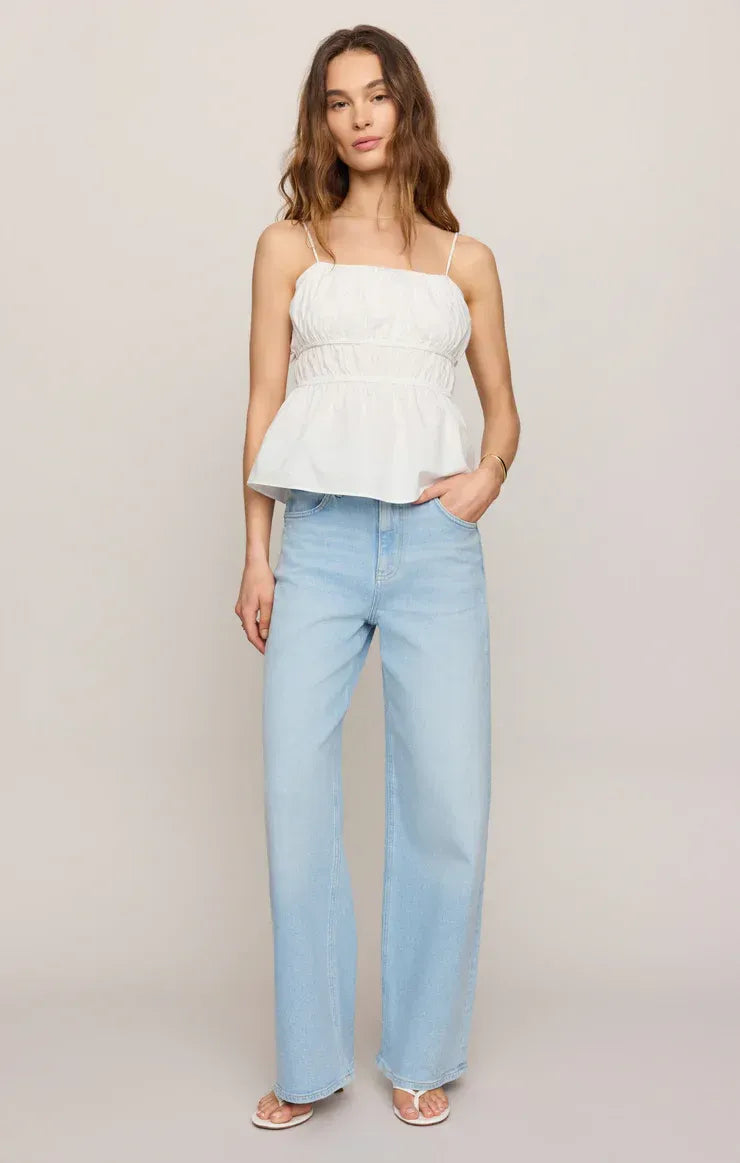 White peplum adele back tie top with thin straps paired with light blue wide-leg jeans for womens boho clothes