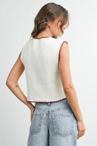 White ribbed knit sleeveless cardigan with red scalloped trim