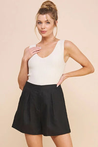 White ribbed knit sleeveless top with deep v-neckline and high waist linen pleat shorts