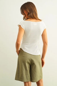 White crinkled fabric shirring cap sleeve top with ribbed texture and slightly curved hemline for casual wear