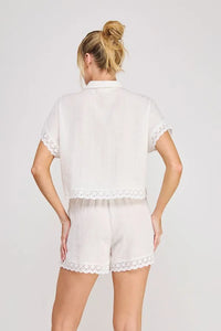 White linen blend short sleeve dolman button front top with delicate lace trim along cuffs and hem