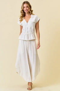White short-sleeved peplum top with zip closure and drawstring waist paired with matching wide-leg linen vest pants