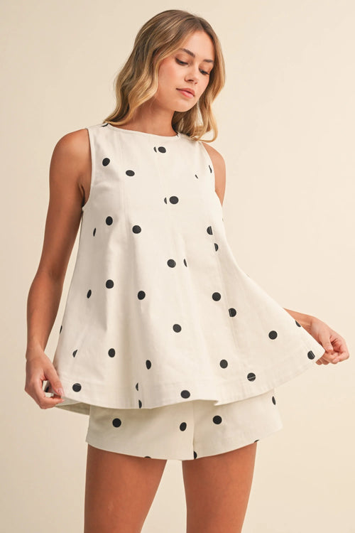 White sleeveless polka dot denim longline top with black dots paired with matching shorts for casual wear