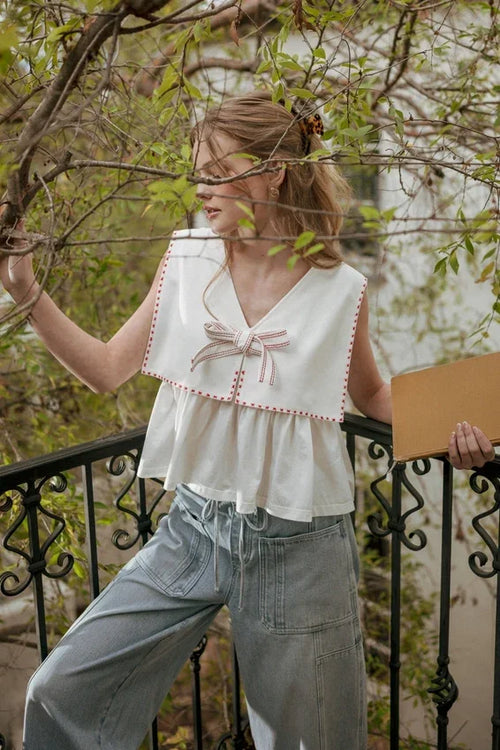 Sailor collar sleeveless top with white fabric, red stitching and bow
