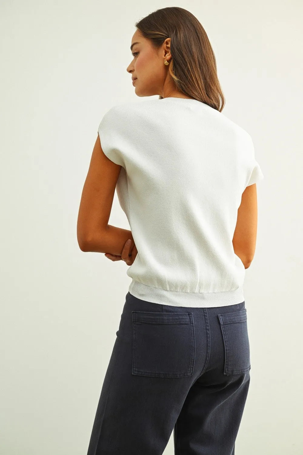 White sleeveless knit top with relaxed fit and ribbed hem suitable as a cap short sleeve knit top option