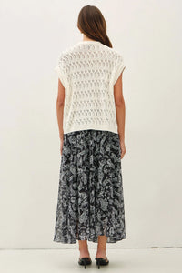 White sleeveless crochet knit boxy top with detailed lace pattern complementing knit boxy open cardigan style