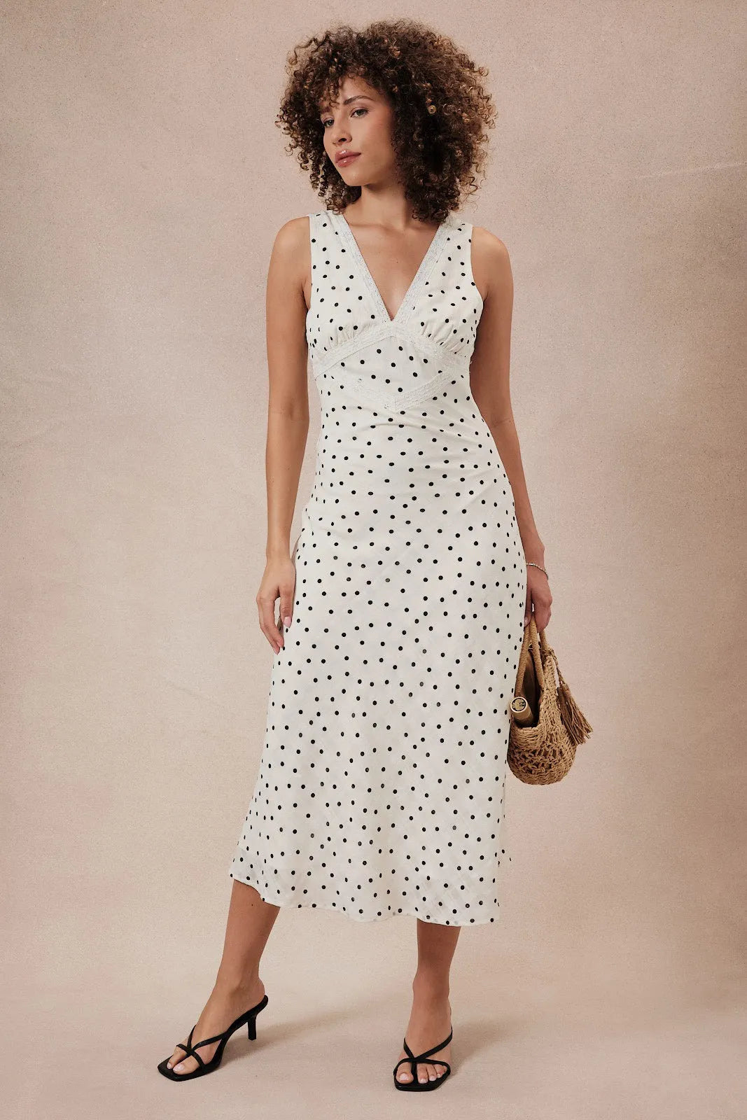 White sleeveless midi dress with black polka dots featuring a lace detail v neck sleeveless midi design