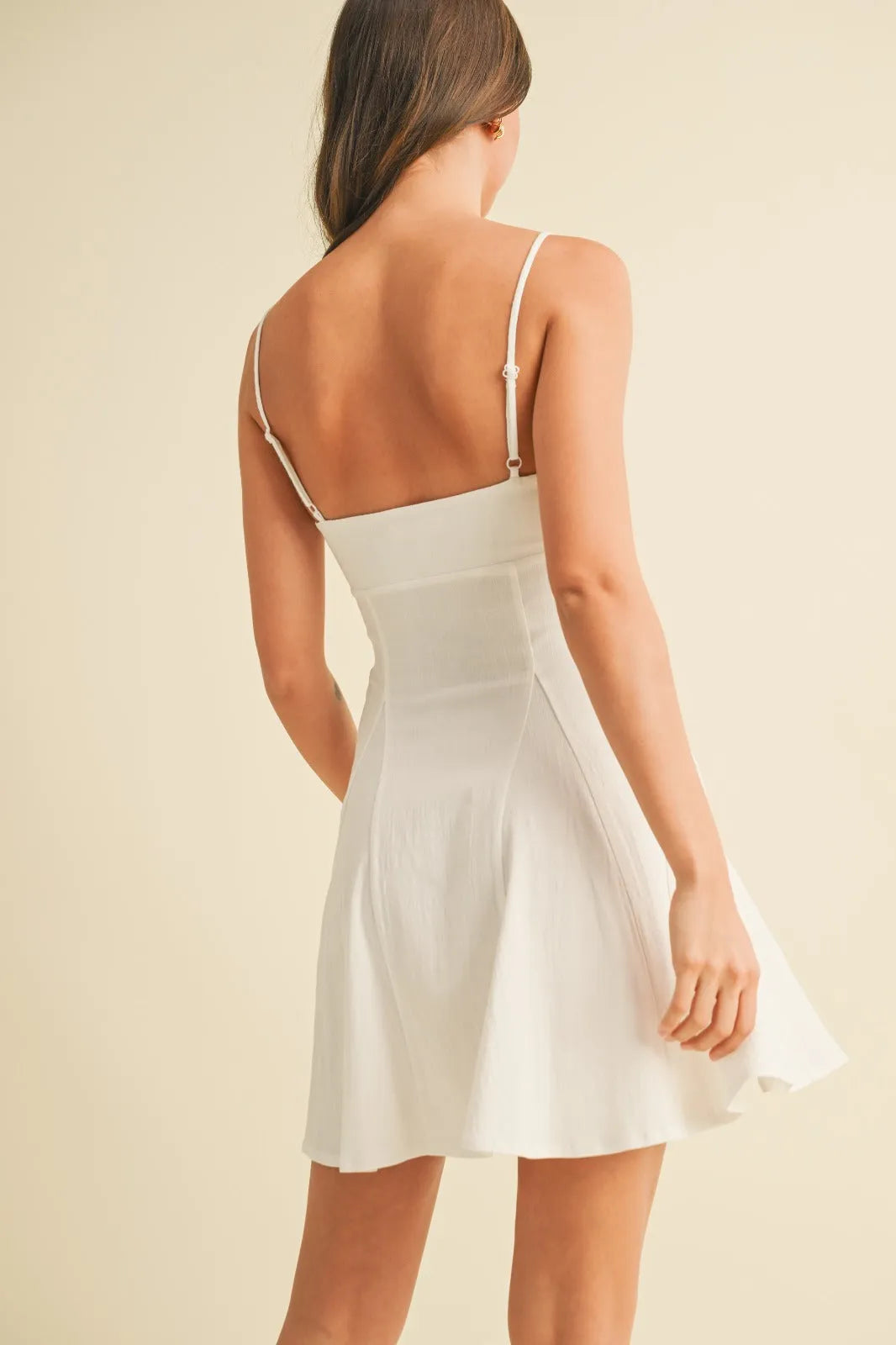 White sleeveless stretchy linen flare mini dress with thin straps and a flared skirt perfect for summer wear