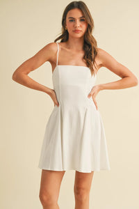 A white sleeveless mini dress with thin straps and a flared skirt made of stretchy linen flare fabric