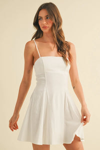 White sleeveless mini dress with thin straps in stretchy linen flare material featuring a flared skirt design