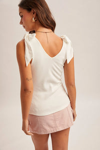 White sleeveless v neck ribbed top with bow tie detail and ruffled shoulder bows shown from back side