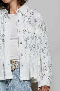 White textured button-up shacket with floral ruffle detailing and vertical ribbed fabric front pocket design