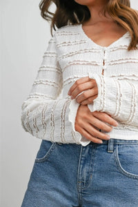 White textured ruched ribbon knit cardigan with ruffled cuffs and button-front closure