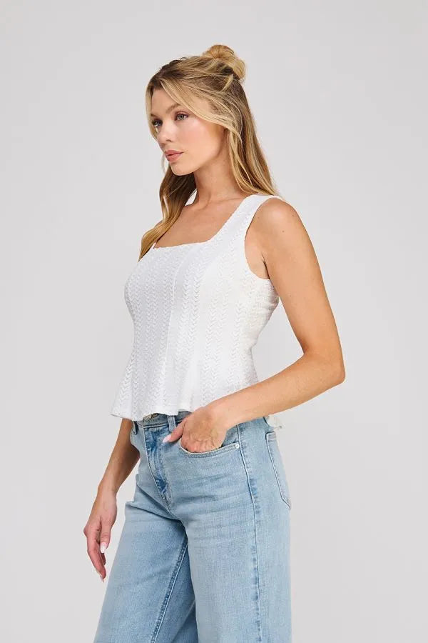 White textured sleeveless zig zag blouse with square neck zig neckline and peplum hem for elegant wear