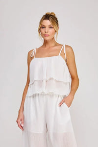White tiered chiffon camisole top featuring a textured woven tie strap ruffle design with adjustable thin straps