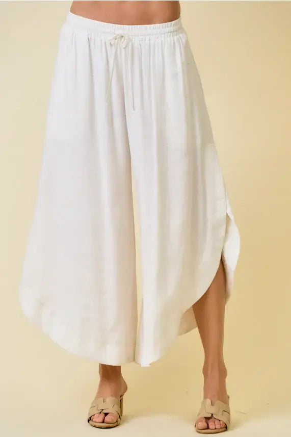 White flowing wide-leg pants with rounded hem and drawstring waist perfect for women’s boho chic clothing shop Daisy