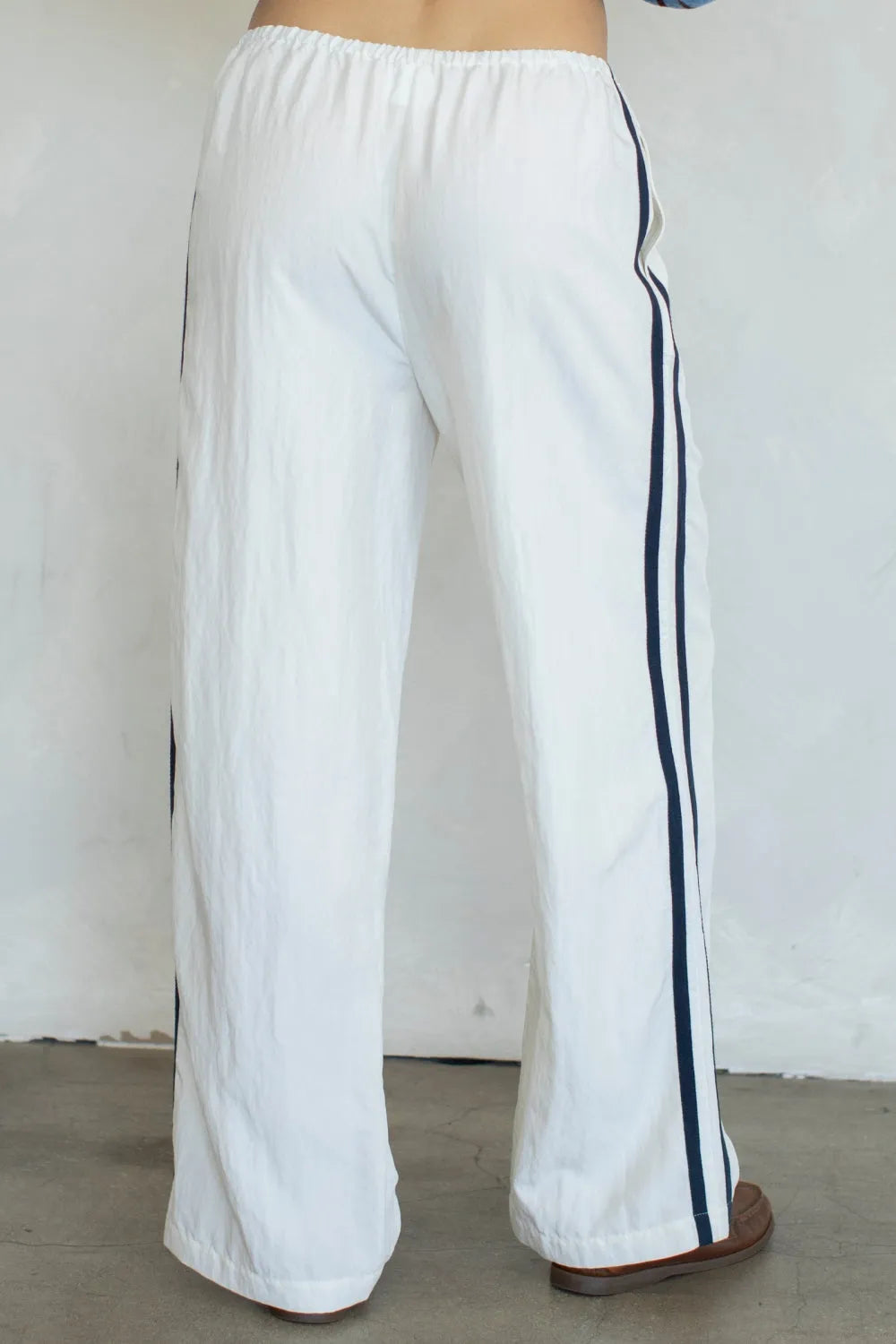 White landon track pocket double line pants with wide-leg design and navy blue side stripes for athletic wear