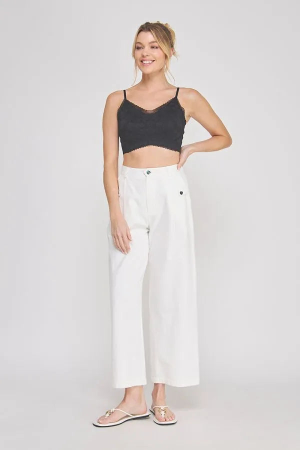 White wide-leg trousers with subtle side pockets paired with an adjustable spaghetti strap padded lace bralette