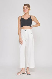 White wide-leg trousers with subtle side pockets paired with an adjustable spaghetti strap padded lace bralette