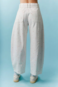 High waist white wide-leg trousers with subtle red mini bow print and waist tie in barrel denim style