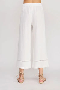 White wide-leg linen blend crop pants with delicate lace trim at the hem in a linen blend crop style