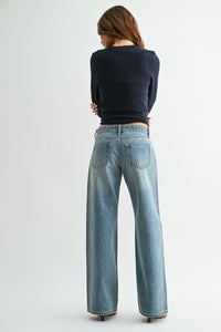 Wide-leg denim jeans in light blue wash with low rise baggy fit classic back pockets and belt loops shown from the back side