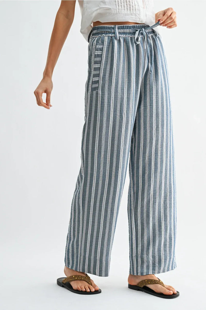 Striped wide leg drawstring pants in soft blue and white vertical stripes with elastic waistband and drawstring closure