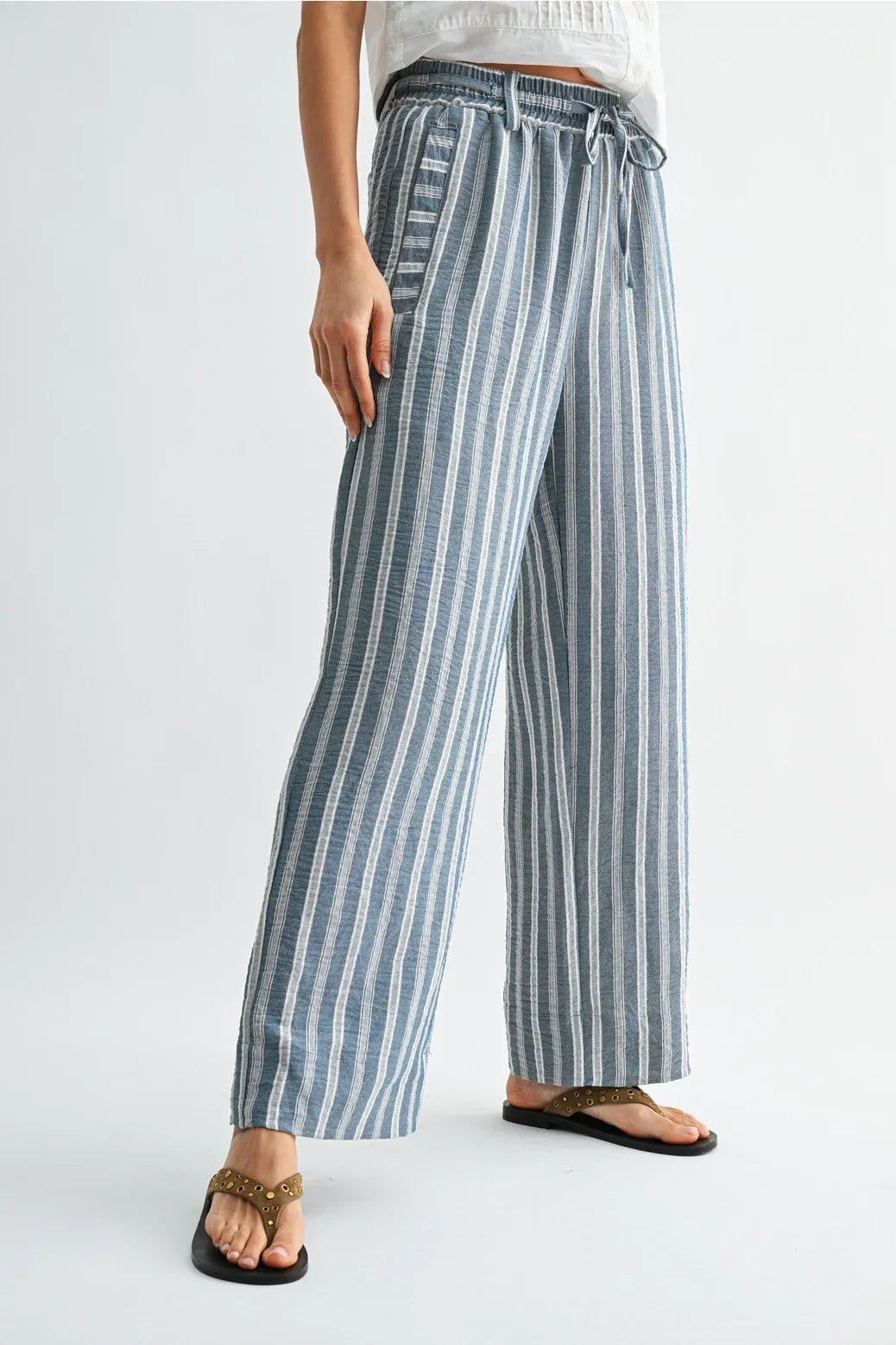 Striped wide leg drawstring pants in soft blue and white vertical stripes made from lightweight woven fabric