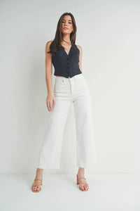 Woman modeling slim wide leg jeans with scissor cut hem in light wash denim
