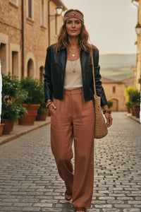 Woman in heritage faux leather jacket, beige top, rust pants
