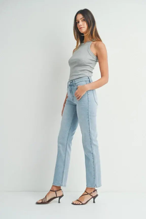 Woman wearing high waist straight leg denim jeans and black strappy kitten heels