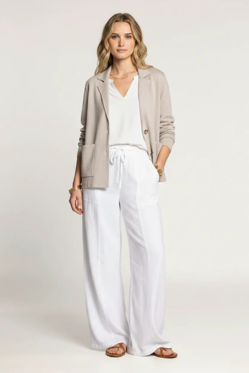 Woman in knitted relaxed fit blazer with white wide-leg trousers