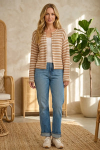 A woman wearing a beige and cream striped knit open ribbed cardigan with ribbed cuffs