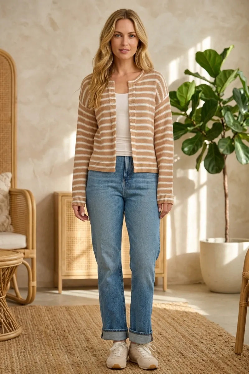 A woman wearing a beige and cream striped knit open ribbed cardigan with ribbed cuffs