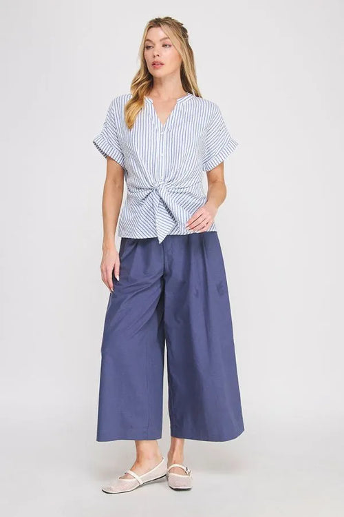A woman wears a blue and white striped button down striped front tie detail v neck top from shop daisy womens boho clothes