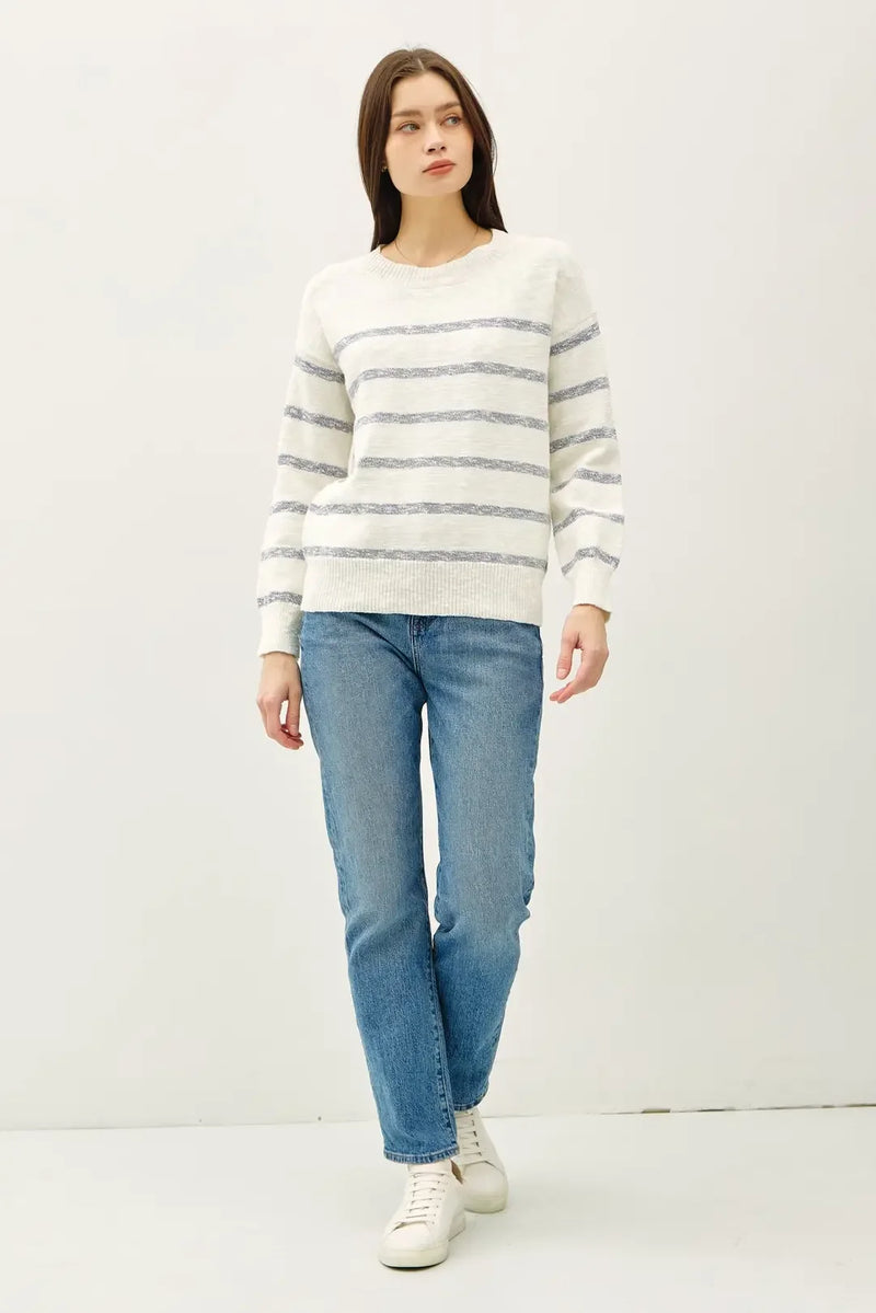 Woman in Heather striped long sleeve sweater with jeans