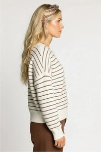 Woman in Thread & Supply Ely sweater, cream brown striped knit with ribbed cuffs
