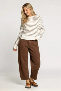 Woman in Thread & Supply Ely sweater with cream black stripes, brown wide-leg trousers