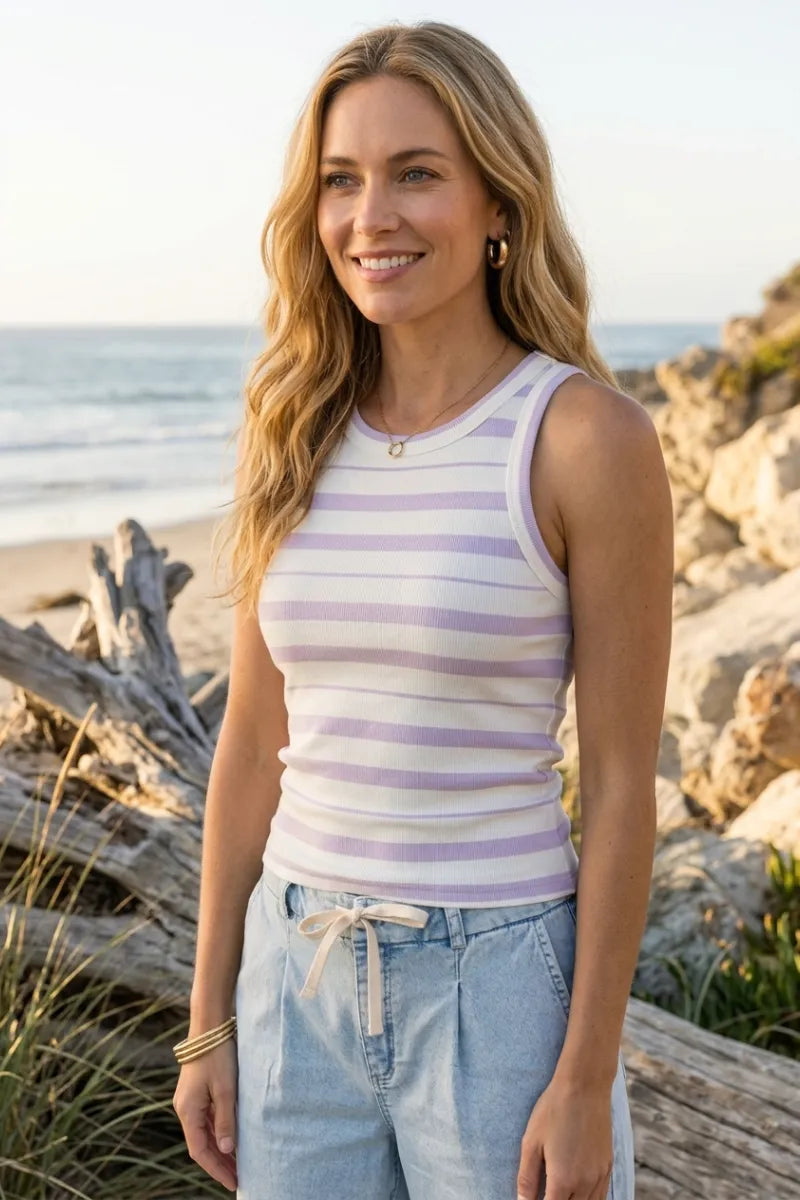 A woman wears a lavender and white striped ribbed cotton edlin basic tank with a rounded neckline