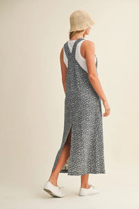 Woman in ditsy floral overall dress with cross-back straps, side slit