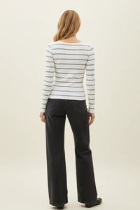 Woman in classic ribbed scoop neck long sleeve top with gray striped design and dark flared jeans