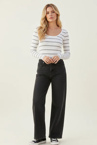 Woman in classic ribbed scoop neck long sleeve top with striped top and black jeans