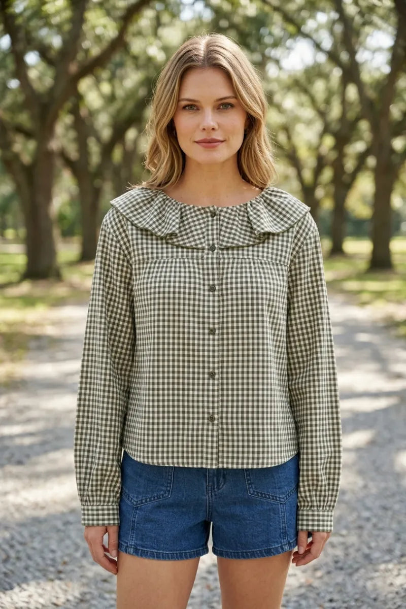 A woman wears a long-sleeved mini gingham ruffled collar blouse with green and white gingham pattern and button-up front