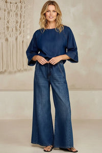 Woman in drawstring wide leg denim: navy blue top with bell sleeves