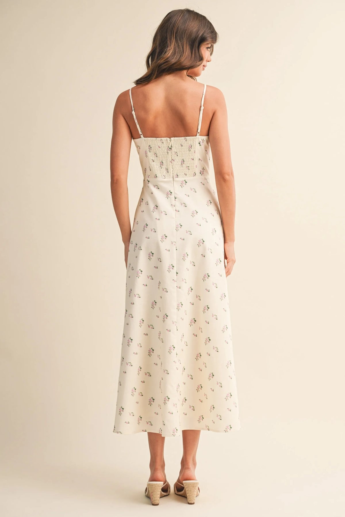 A woman wearing an off-white floral twill paneled midi dress with delicate floral embroidery on the back straps and bodice